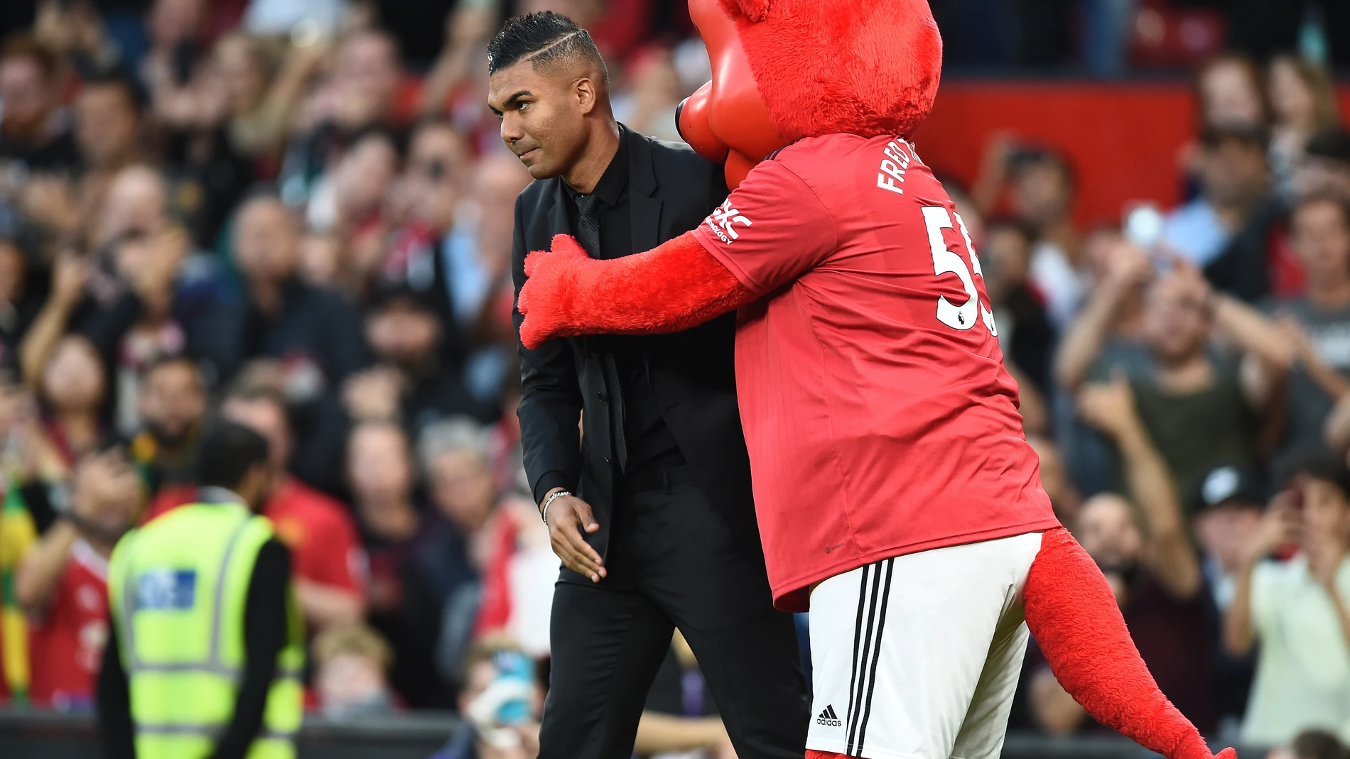 Casemiro, con la mascota del Manchester United, Fred the red