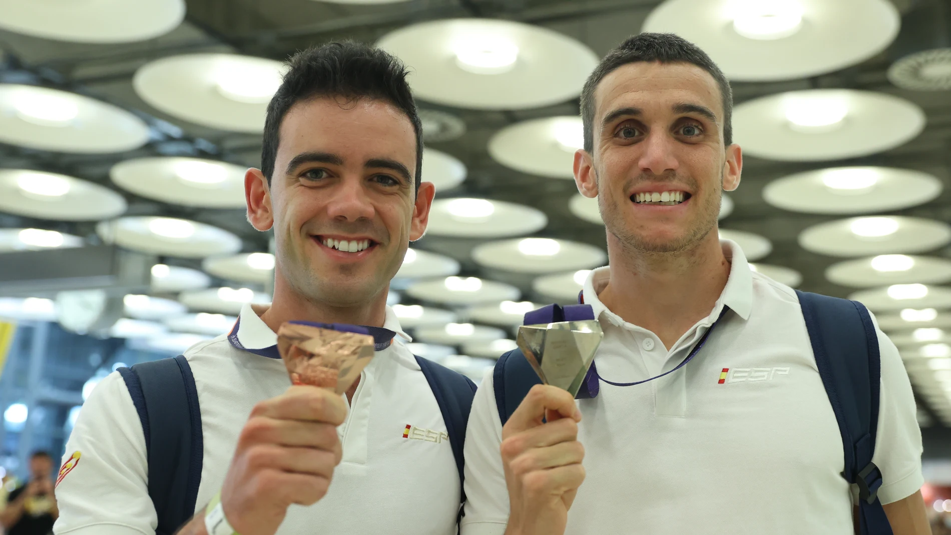 Diego García, bronce en los 20 kilómetros marcha, y Mariano García, oro en 800, muestran sus medallas de los Europeos a su llegada a Barajas