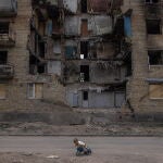 Un niño juega frente a un edificio residencial destruido en Horenka, en la región de Kyiv