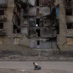 Un niño juega frente a un edificio residencial destruido en Horenka, en la región de Kyiv