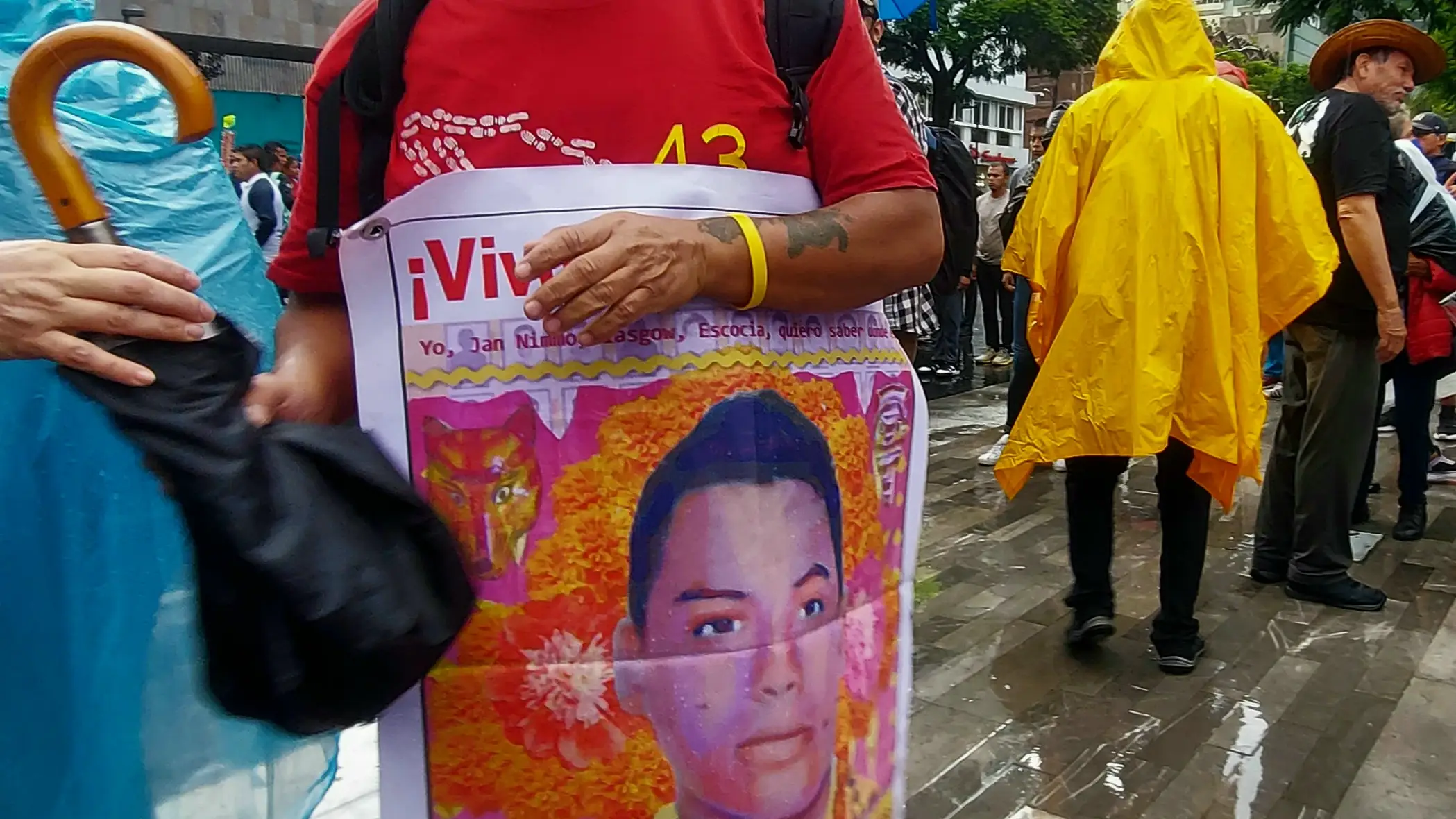 Clemente Rodríguez sonríe portando la pancarta de su hijo, Cristian Alfonso, uno de los 43 estudiantes de Ayotzinapa, después de la manifestación el viernes por la tarde en Ciudad de México.