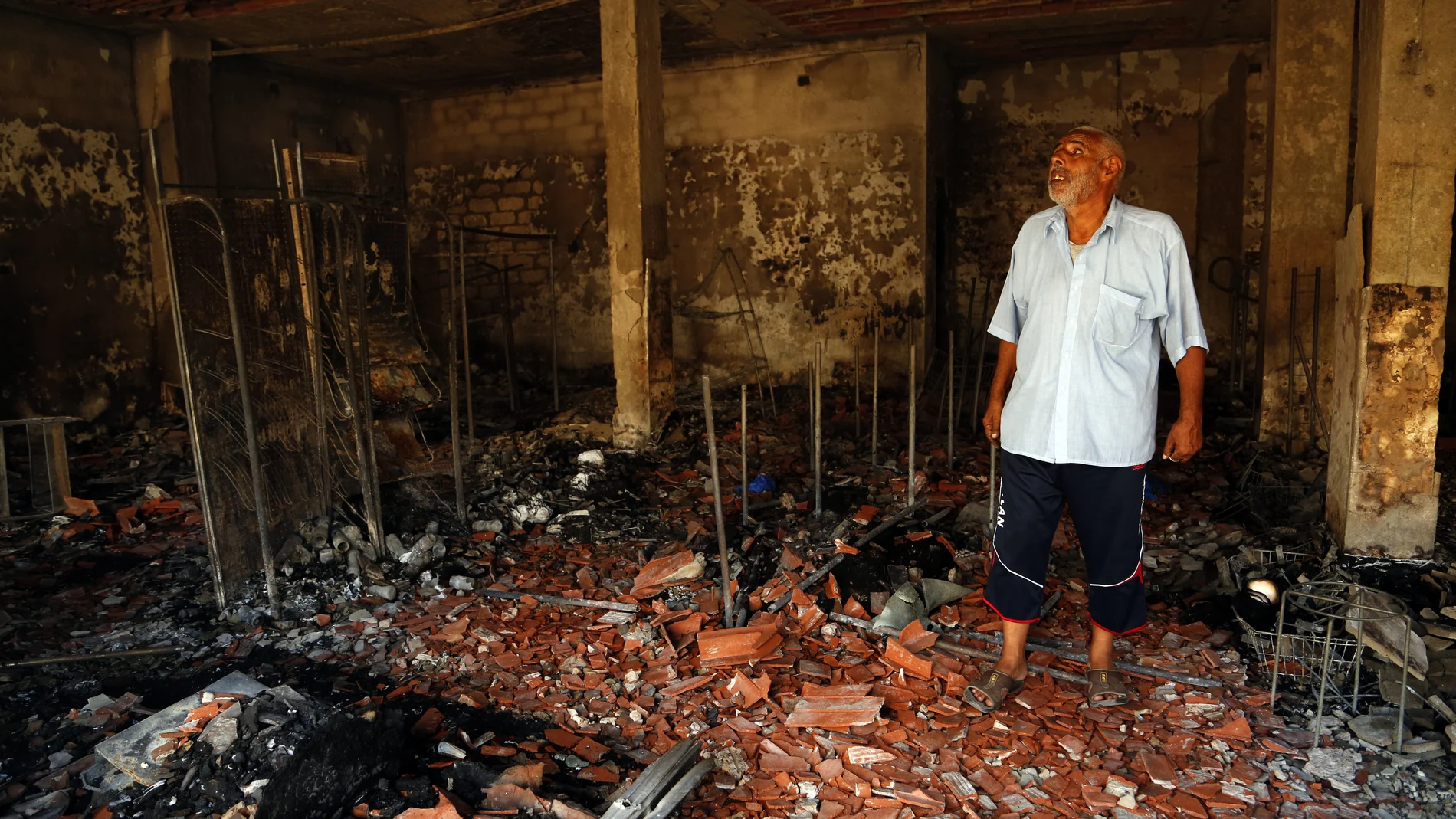 Un hombre supervisa los destrozos producidos durante los enfrentamientos en la capital de Libia, Trípoli este sábado