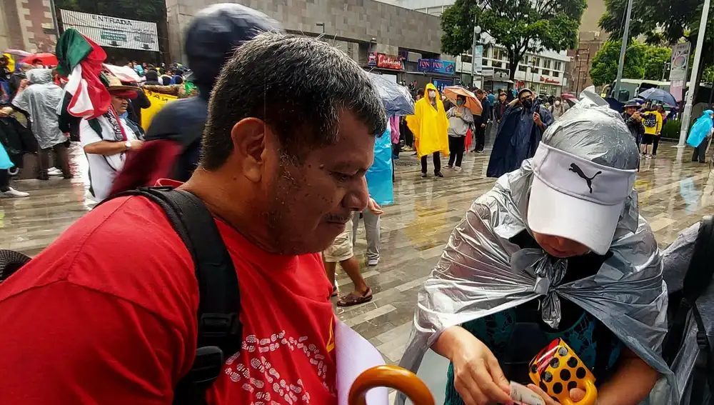 Clemente Rodríguez, padre del estudiante desaparecido Cristian Alfonso Rodríguez, vende por 80 pesos mexicanos (cuatro euros) una taza de artesanía a una manifestante tras la marcha por la desaparición de los 43 alumnos desaparecidos el 26 de septiembre de 2014.