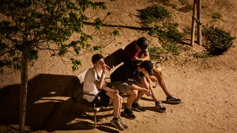 Jóvenes bebiendo en la calle en un parque en Madrid.