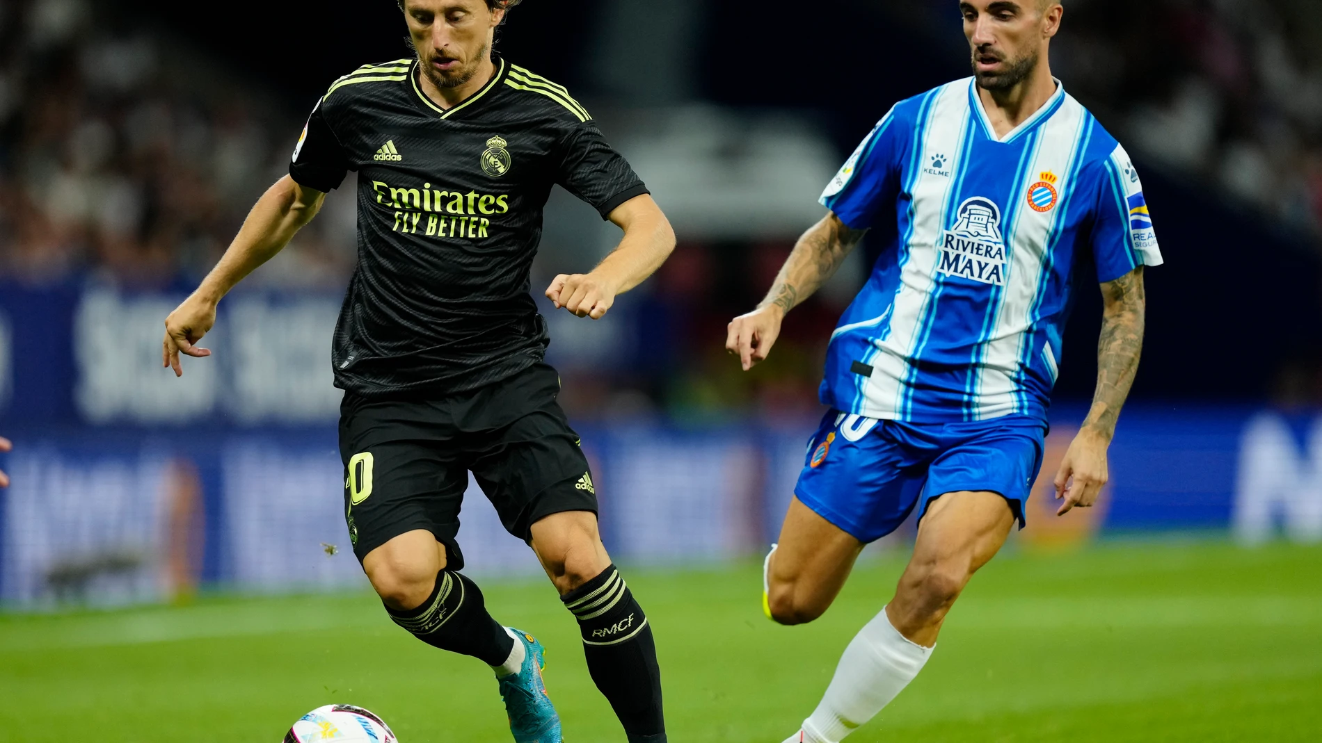 El centrocampista del Real Madrid Luka Modric (i) se escapa de Sergi Darder, del RCD Espanyol, durante el partido de la tercera jornada de LaLiga que RCD Espanyol y REal Madrid juegan hoy domingo en el RCDE Stadium. EFE/Enric Fontcuberta
