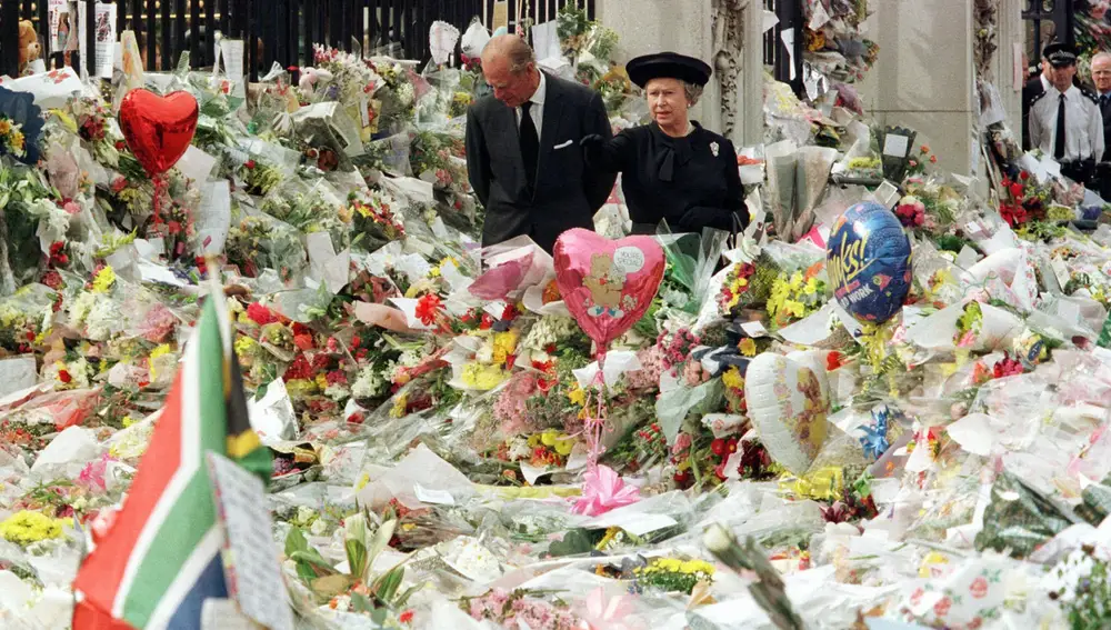 La reina Isabel II y el príncipe Felipe, paseando entre las flores y fotografías que depositaron los británicos el día del funeral de Diana de Gales (Pool Photo via AP, File)