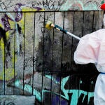 Un operario limpia una pared de los grafitis pintados con motivo de la puesta en marcha de las ‘patrullas antigrafiti