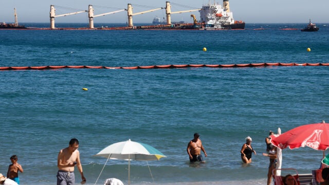 Bañistas en la playa de la Caleta, en Gibraltar, observan el buque varado