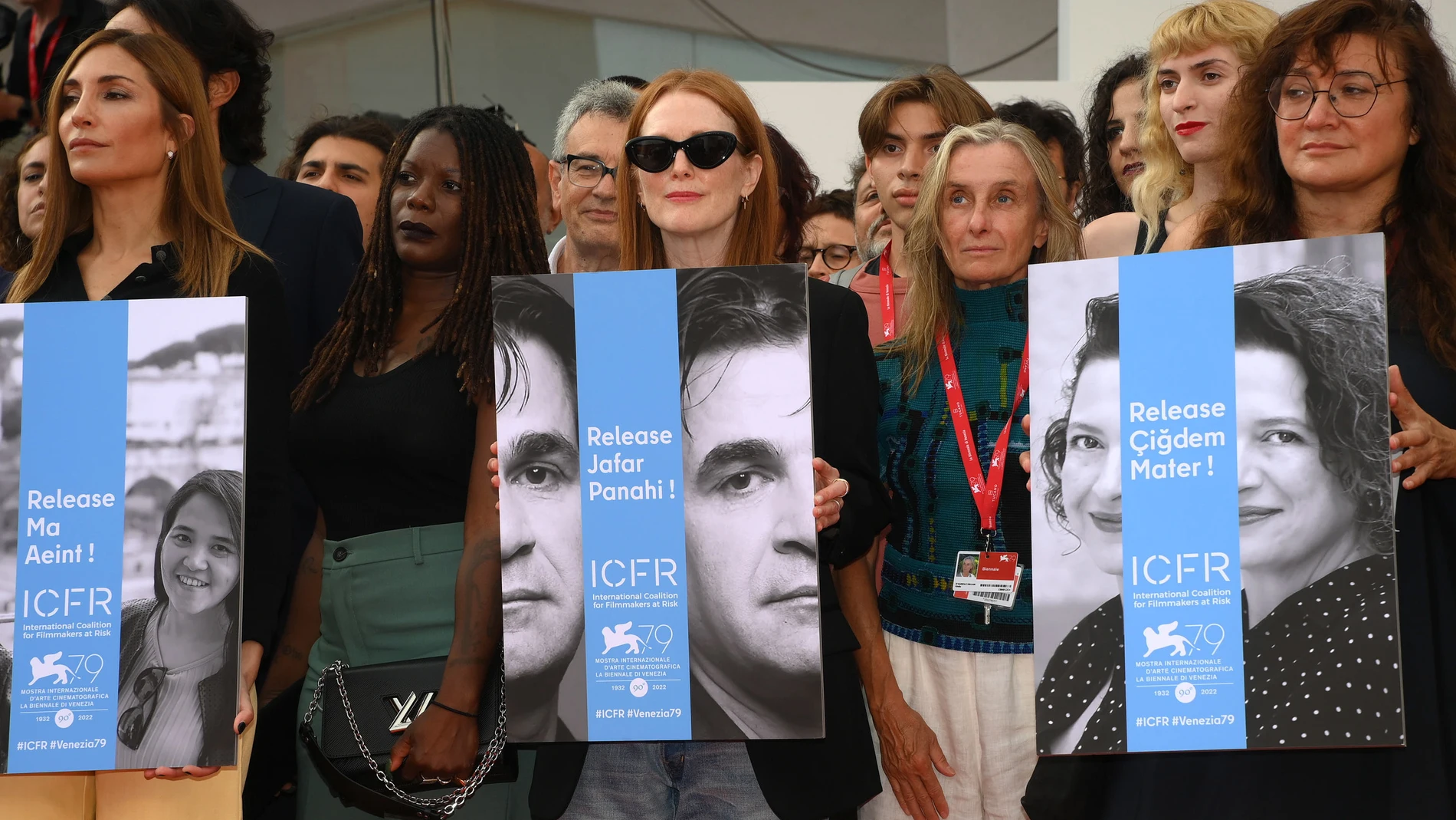 De izda. a dcha.: Audrey Diwan, Julianne Moore (sosteniendo un cartel reivindicativo con el rostro de Jafar Panahi) e Isabel Coixet, en la Mostra