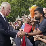 Carlos III saluda a la gente a su llegada al palacio de Buckingham