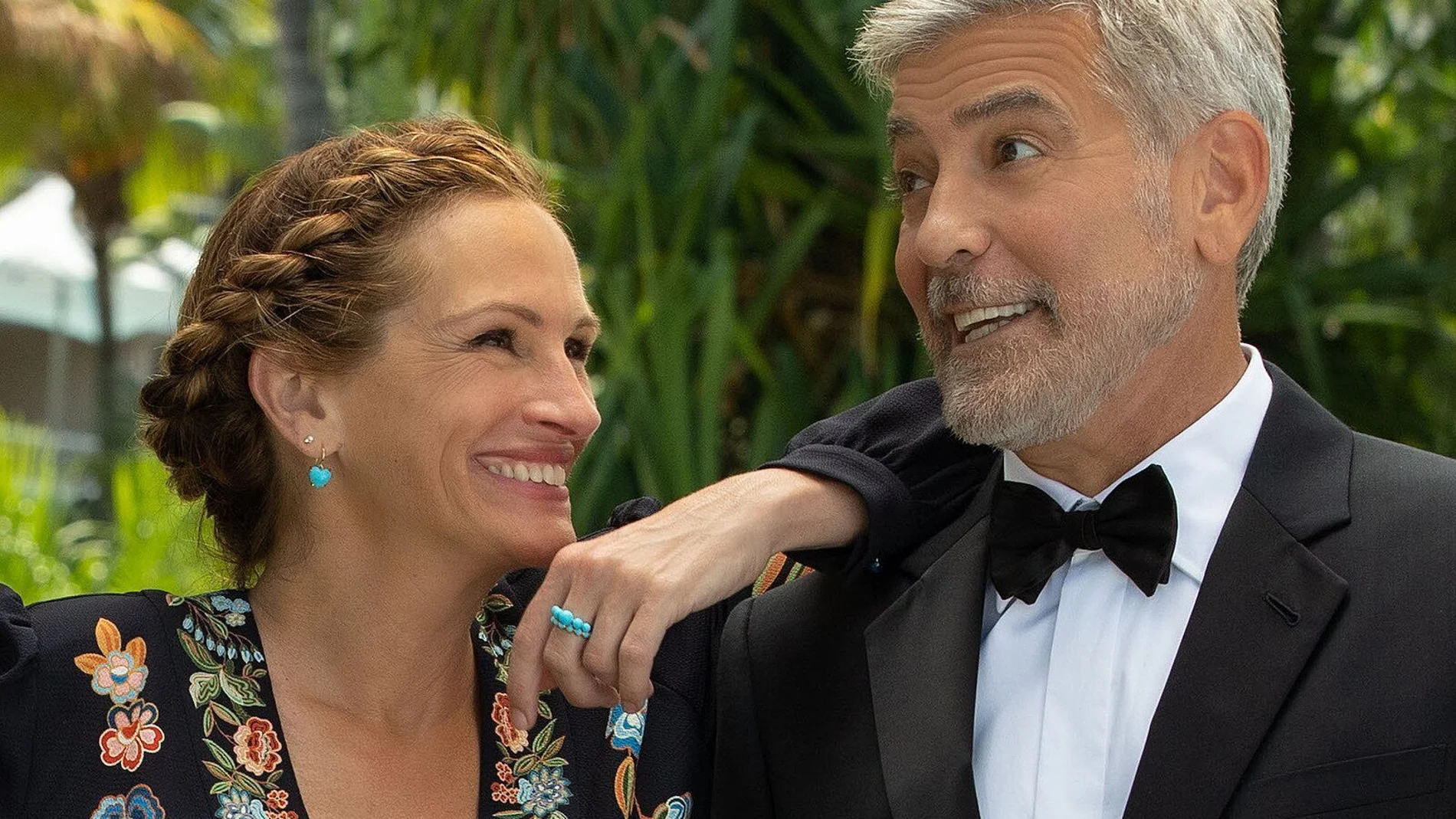 Julia Roberts se apoya en el hombro de George Clooney durante un momento del rodaje del filme, donde ambos, vestidos para la ocasión, esperan que comience la boda de su hija