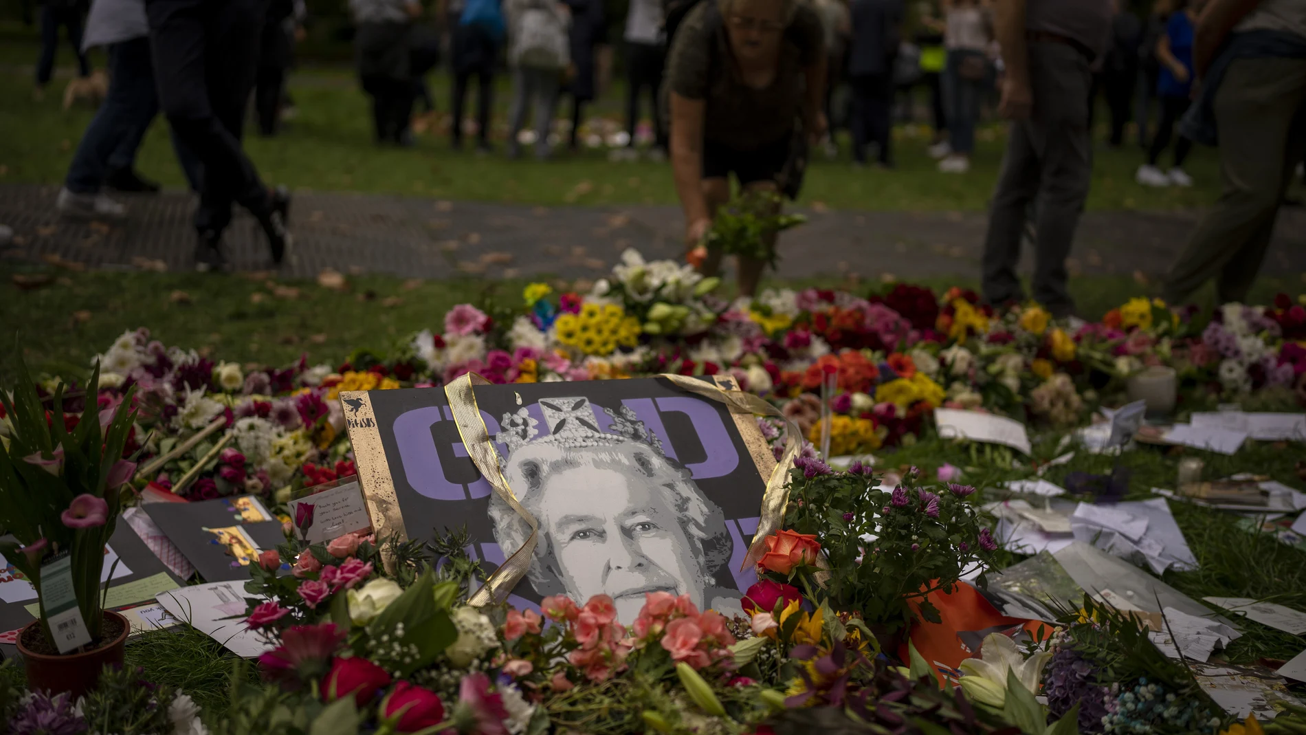 Flowers and candles for Queen Elizabeth II are seen at the gates outside Buckingham Palace in London, Saturday, Sept. 10, 2022. Queen Elizabeth II, Britain's longest-reigning monarch and a rock of stability across much of a turbulent century, died Thursday Sept. 8, 2022, after 70 years on the throne. She was 96. (AP Photo/Emilio Morenatti)