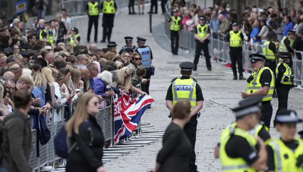 La gente espera la llegada del cortejo de la Reina con el coche fúnebre que contiene su ataúd en la Milla Real de Edimburgo