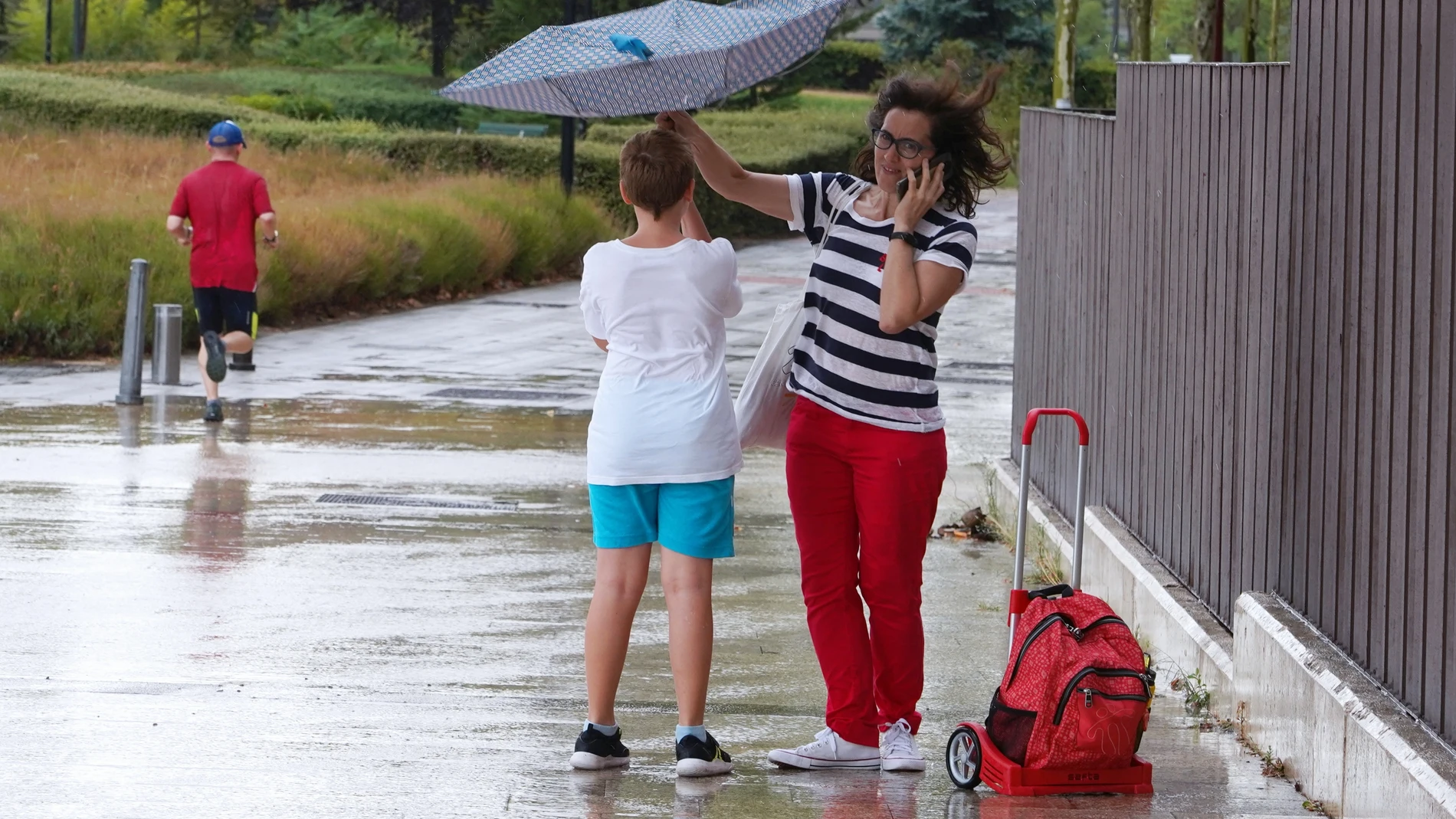 Una madre y un hijo se intentan resguardar de la tormenta en Valladolid