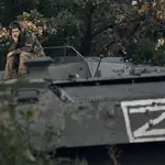 Un soldado ucraniano descansa encima de un vehículo blindado ruso, en Izium, Járkiv