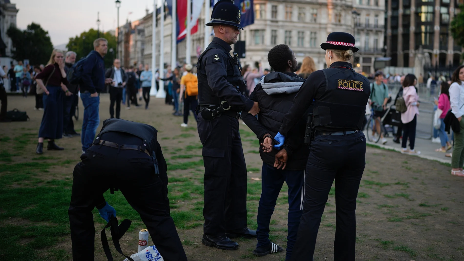 Un hombre es controlado por agentes de policía mientras la gente hace cola para el entierro de la reina Isabel II en Londres, el miércoles 14