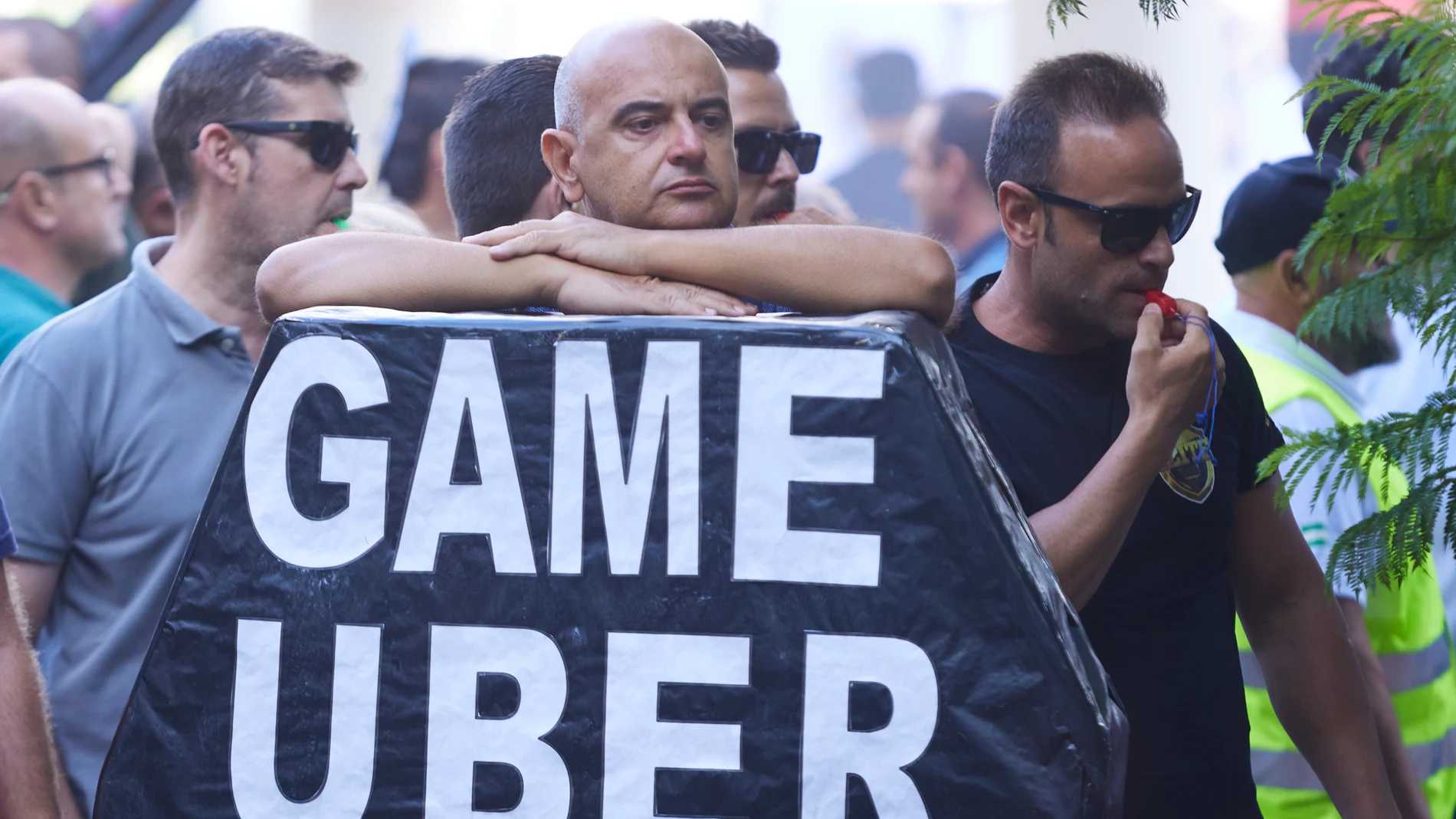 Un manifestante apoyado en el ataúd con el lema “Game Uber”. Joaquín Corchero / Europa Press