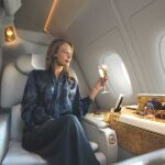 Una pasajera saboreando una copa de champán en un vuelo.