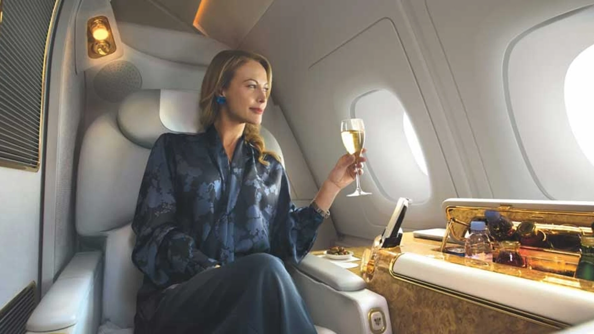Una pasajera saboreando una copa de champán en un vuelo.
