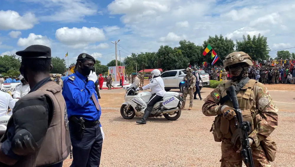 Diferentes miembros de las Fuerzas de Seguridad maliense en el momento previo a la llegada del coronel. Tras ellos, la bandera rusa y los retratos de Goita y de Doumbouya.