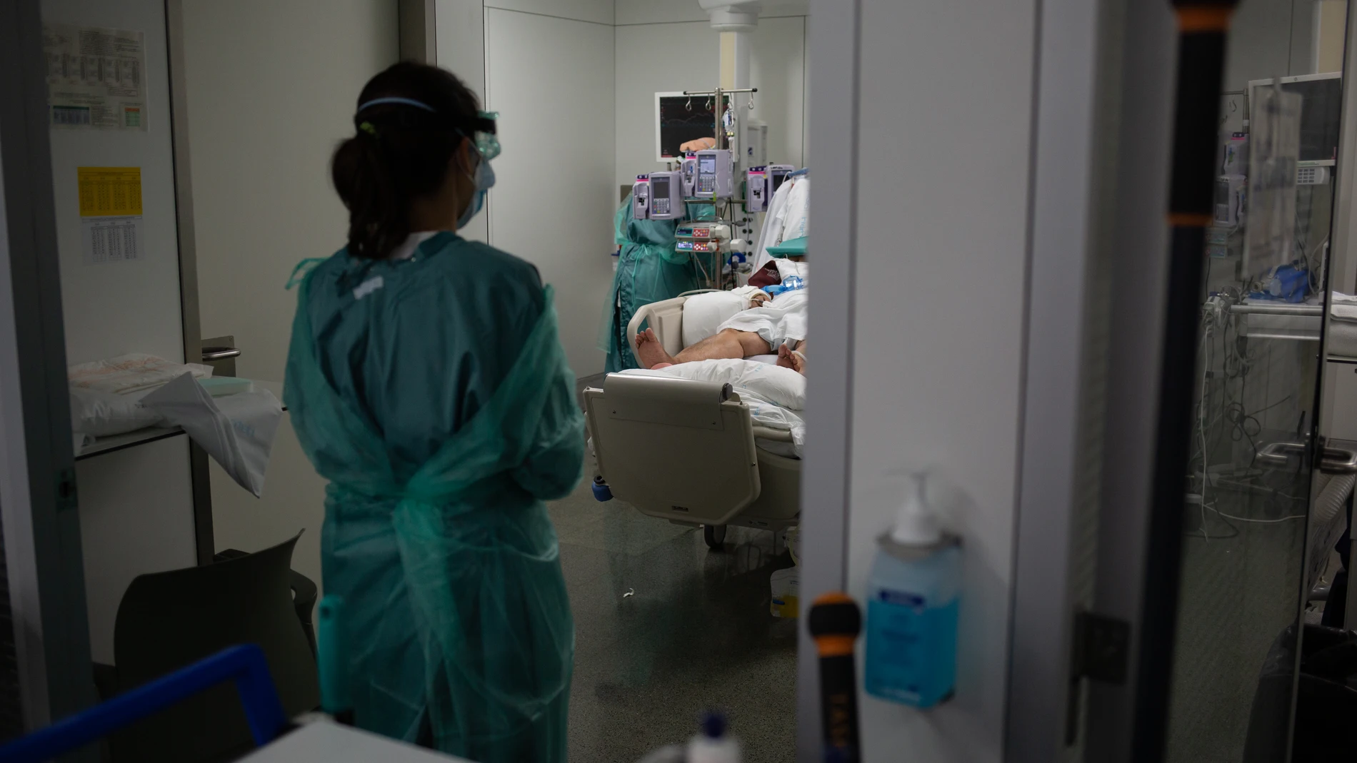 Personal sanitario visita a un enfermo ingresado en una unidad de cuidados intensivos
