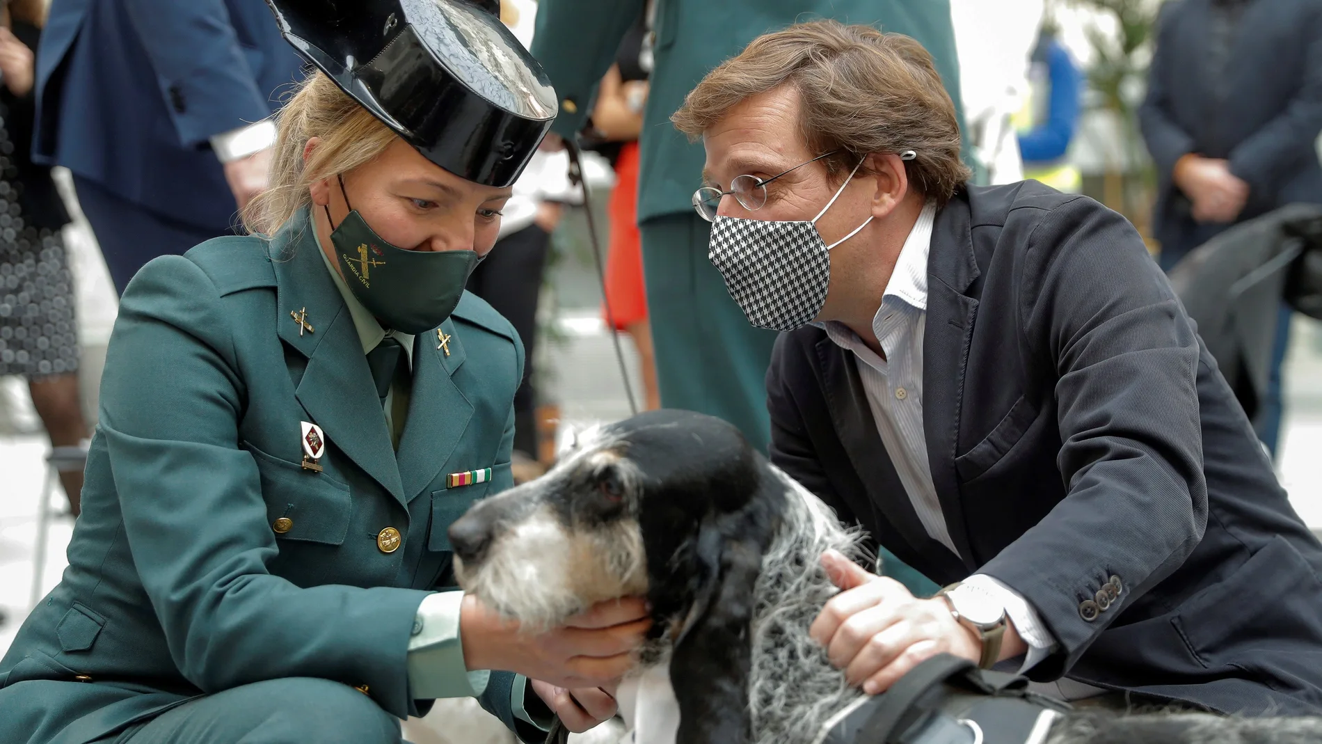 El alcalde de Madrid, José Luis Martínez-Almeida, y una guardia civil, acarician a uno de los perros adoptables durante la presentación de la campaña "Adopta un jubilado 2021"