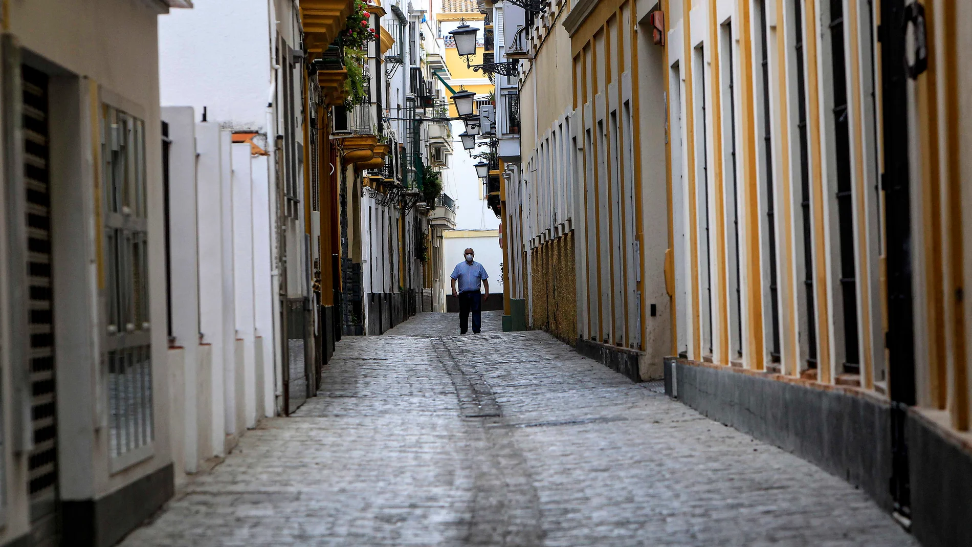 Un hombre con mascarillas, en una calle de Sevilla