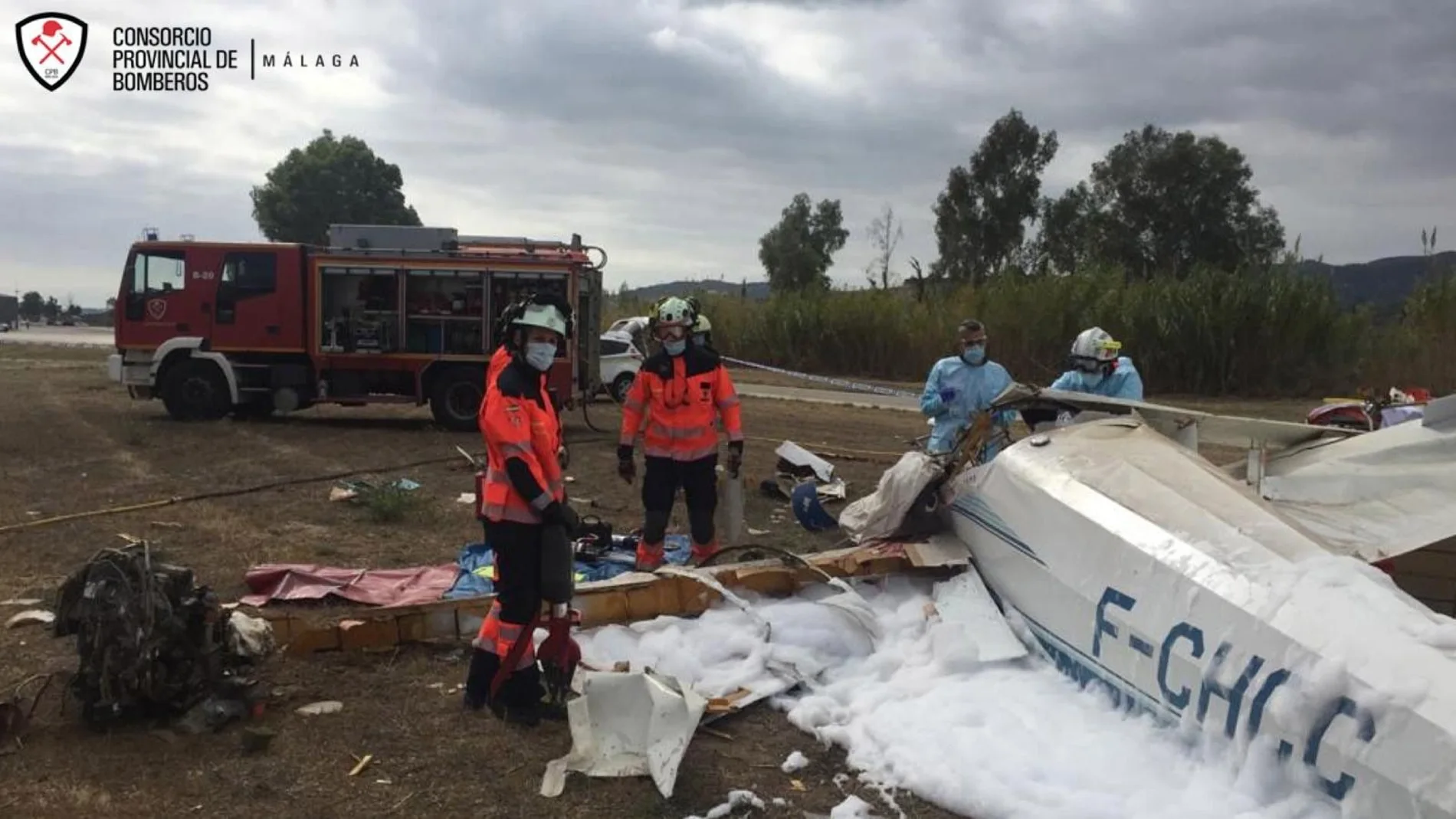 Efectivos del cuerpo de bomberos junto a la avioneta siniestrada en Vélez-Málaga