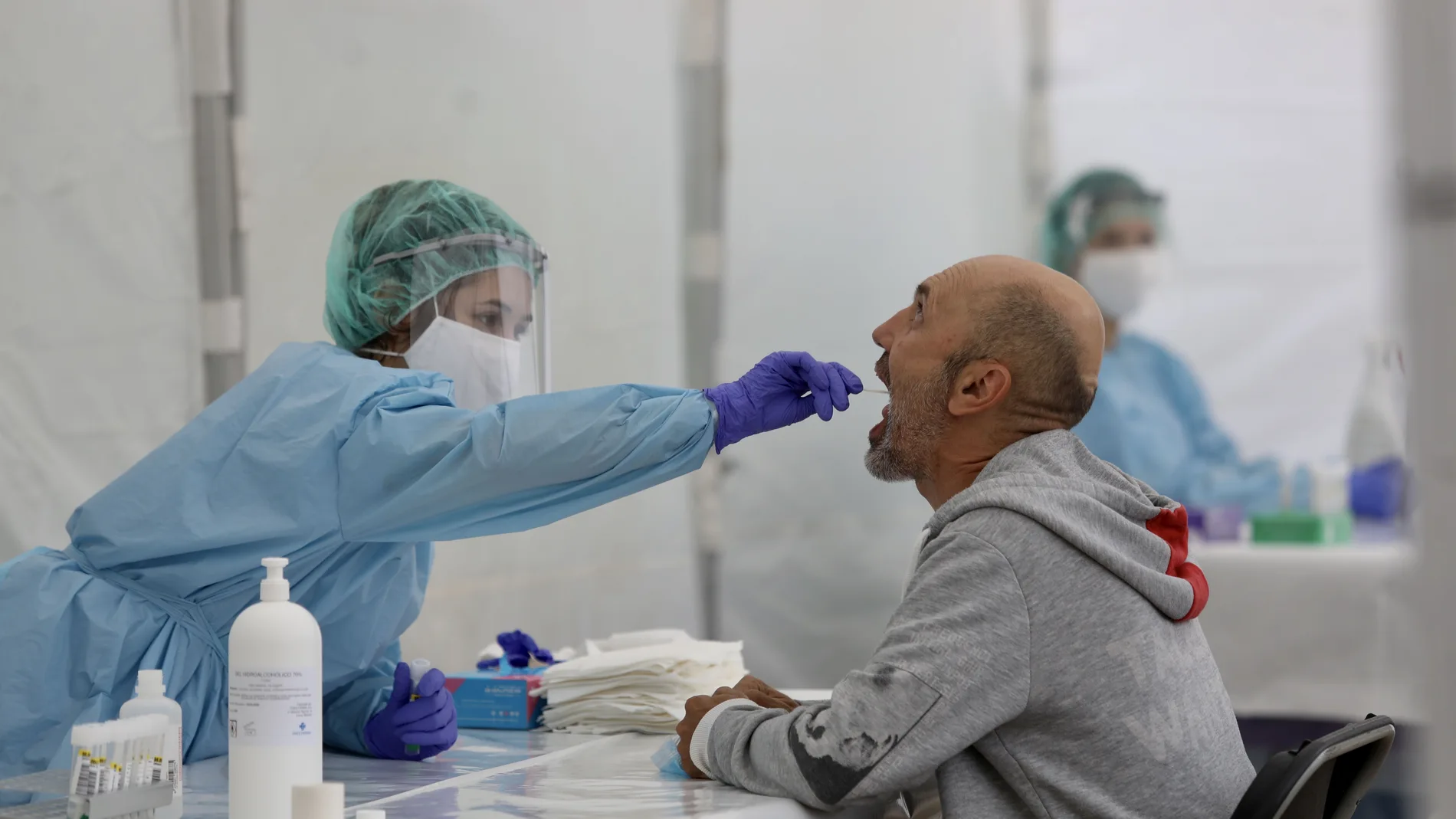 Una sanitaria le realiza un frotis bucal a un paciente para realizar el test que detecta la Covid-19