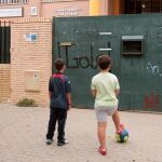 Dos niños frente a un colegio de Andalucía cerrado