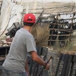 Varias personas observan los restos de una treintena de chabolas de un asentamiento de inmigrantes de Lepe, que ardió recientemente