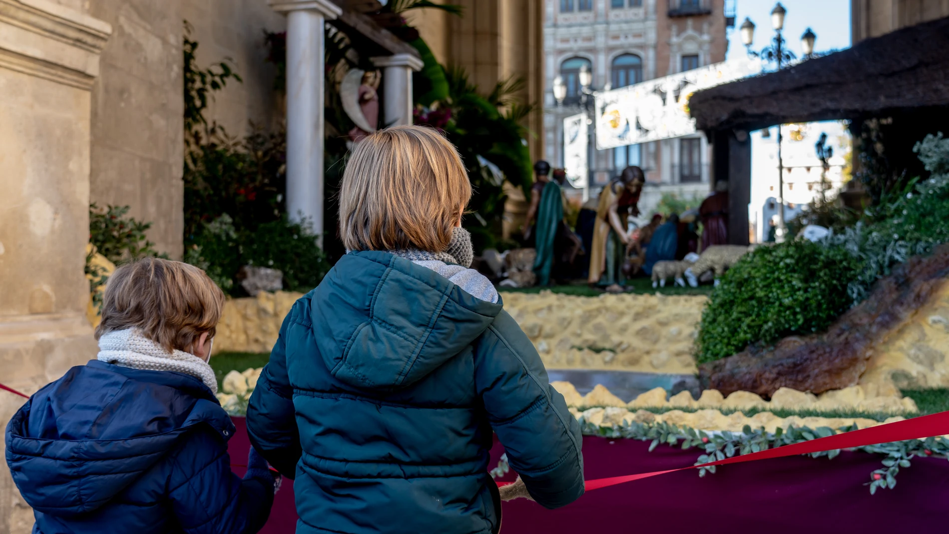 Dos niños contemplan el Belén puesto por el Ayuntamiento de Sevilla