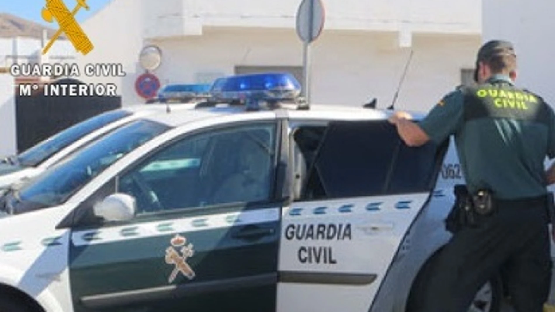 Imagen de un agente y de un vehículo de la Guardia Civil