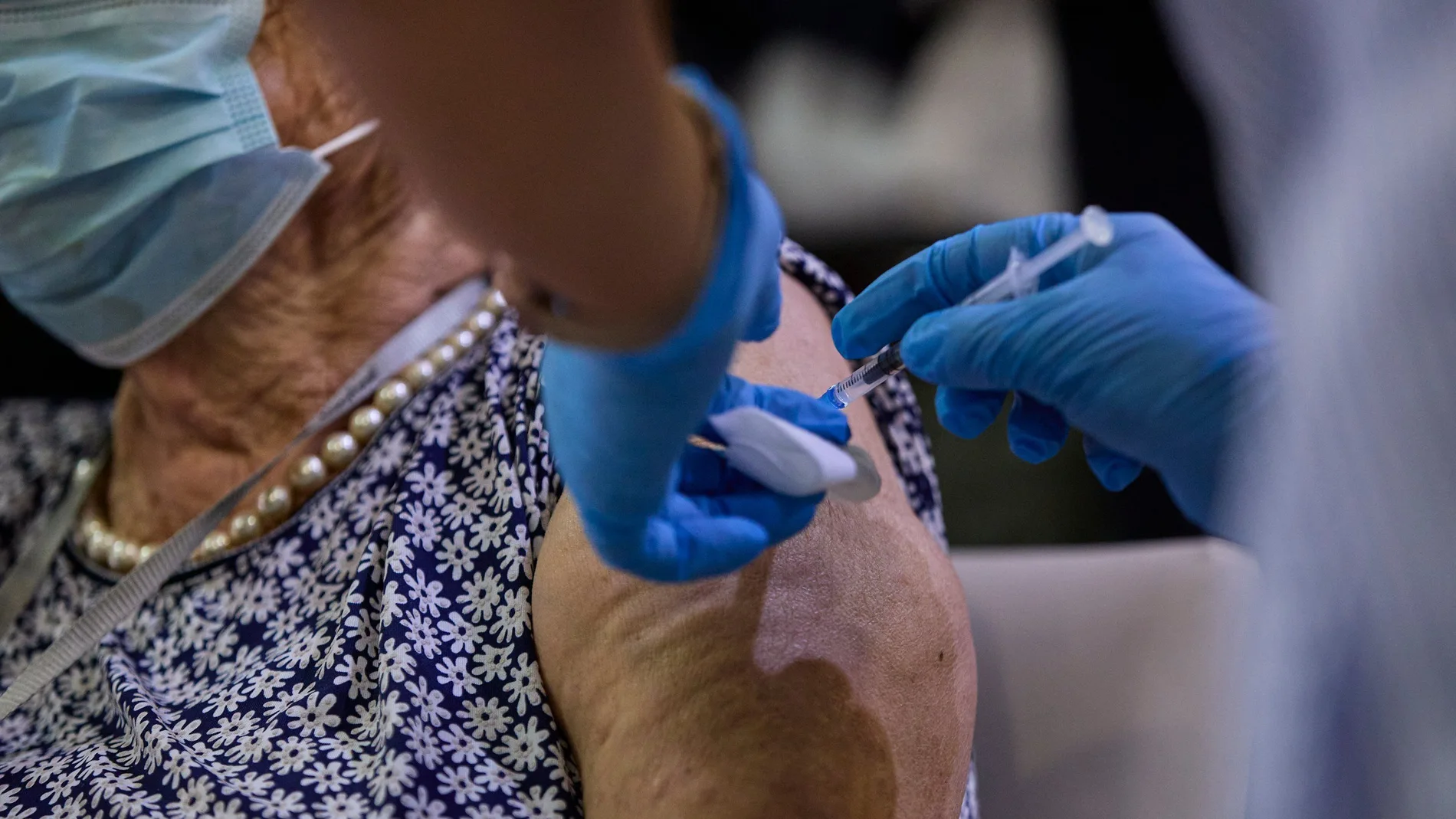 Una sanitaria vacuna a una mujer con la tercera dosis del Covid-19 en Madrid