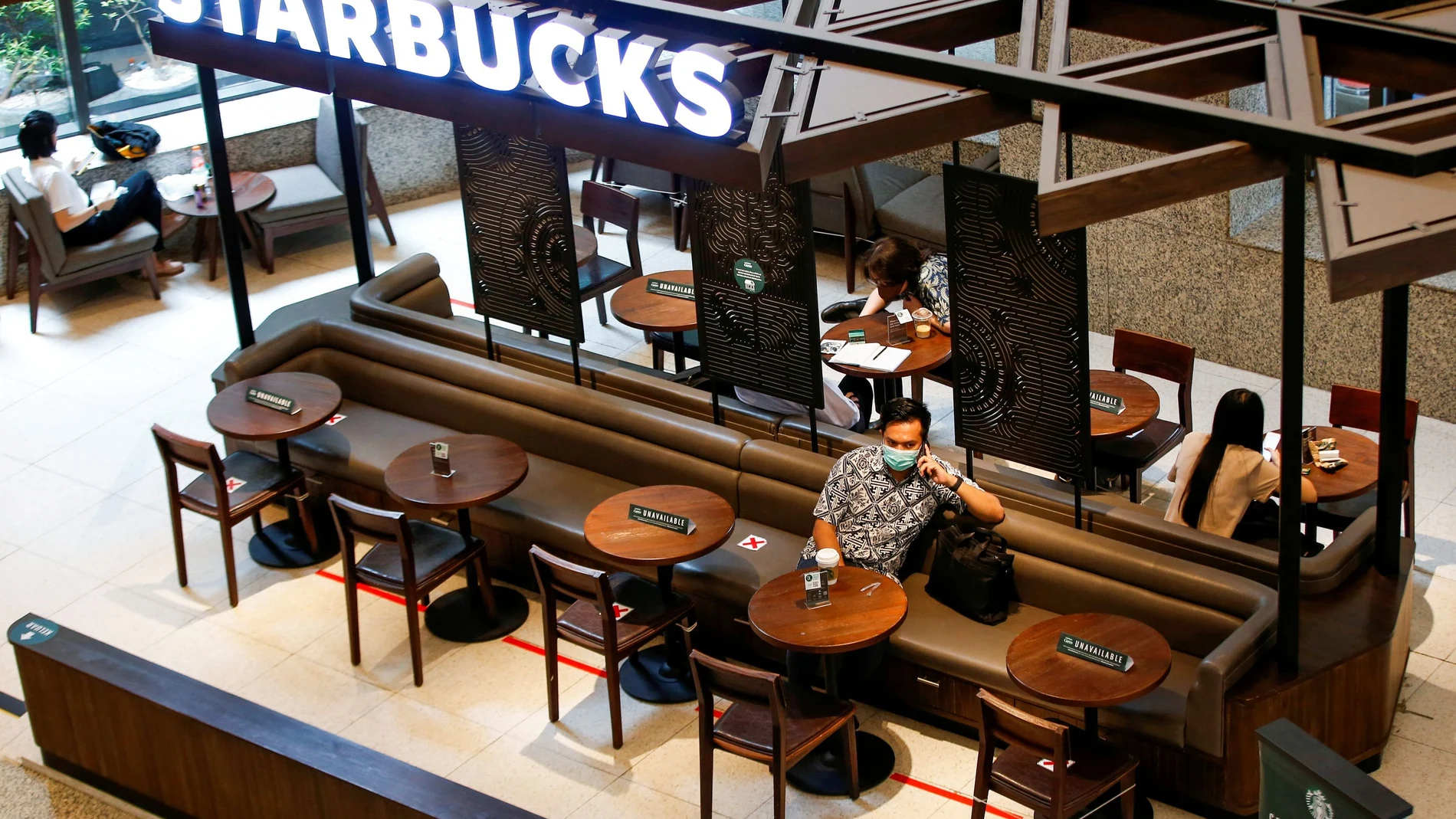 Varias personas en el interior de un local de la cadena Starbucks