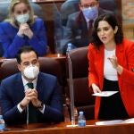 La presidenta de la Comunidad de Madrid, Isabel Díaz Ayuso, toma la palabra en presencia del vicepresidente, Ignacio Aguado, durante la sesión plenaria extraordinaria de la Asamblea de Madrid