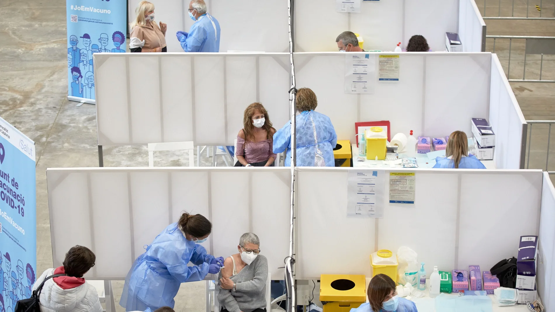Profesionales sanitarios realizan su trabajo en el Palacio de Fires de Girona donde el Departamento de Salud ha establecido un centro de vacunación masivo
