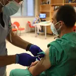 Un trabajador sanitario inyecta una dosis de la vacuna de Pfizer a otro sanitario del Hospital Infanta Sofía de San Sebastián de los Reyes