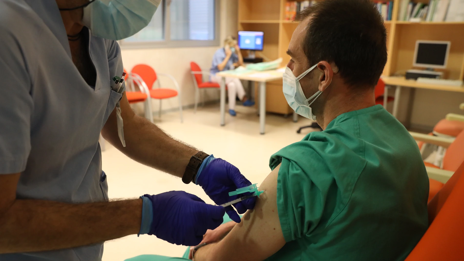 Un trabajador sanitario inyecta una dosis de la vacuna de Pfizer a otro sanitario del Hospital Infanta Sofía de San Sebastián de los Reyes