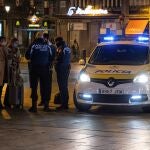 Dos policías municipales paran a tres viandantes en la madrileña Puerta del Sol, este lunes, pasadas las 22.00 horas, hora del nuevo toque de queda