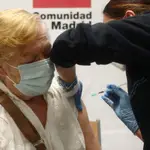 Una sanitaria inyecta la primera dosis de la vacuna de Pfizer contra el coronavirus a una anciana en el Centro de Salud Rejas, en Madrid