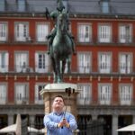 Imagen de un joven haciéndose un selfie con su teléfono movil y un palo en la Plaza Mayor de Madrid
