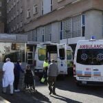 Varias personas con mascarilla en una de las entradas de un hospital de Sevilla