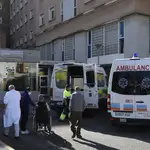Varias personas con mascarilla en una de las entradas de un hospital de Sevilla
