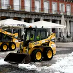 Dos máquinas excavadoras continúan con las tareas de limpieza de calles tras la gran nevada provocada por la borrasca ‘Filomena’, en la Plaza Mayor de Madrid