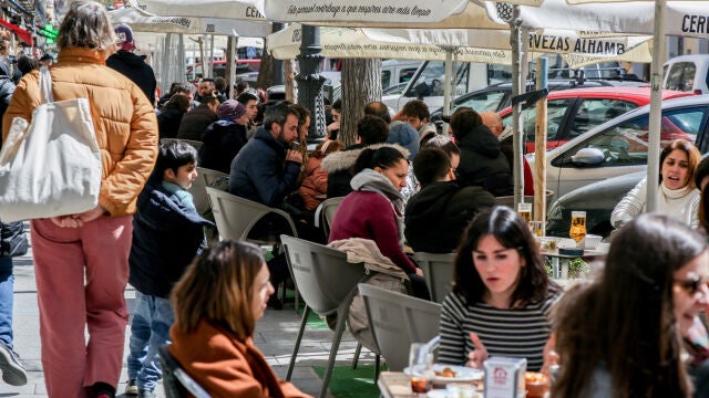 Varias personas sentadas en una terraza en uno de los bares de la calle Argumosa de Madrid
