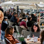 Varias personas sentadas en una terraza en uno de los bares de la calle Argumosa de Madrid