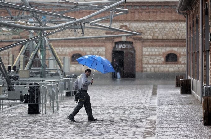 Una persona camina con paraguas bajo una tormenta de verano