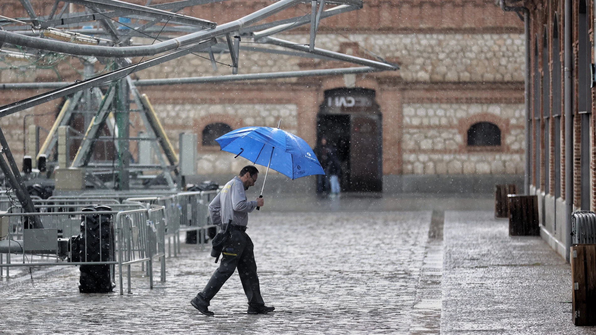 Una persona camina con paraguas en Madrid bajo una tormenta de verano