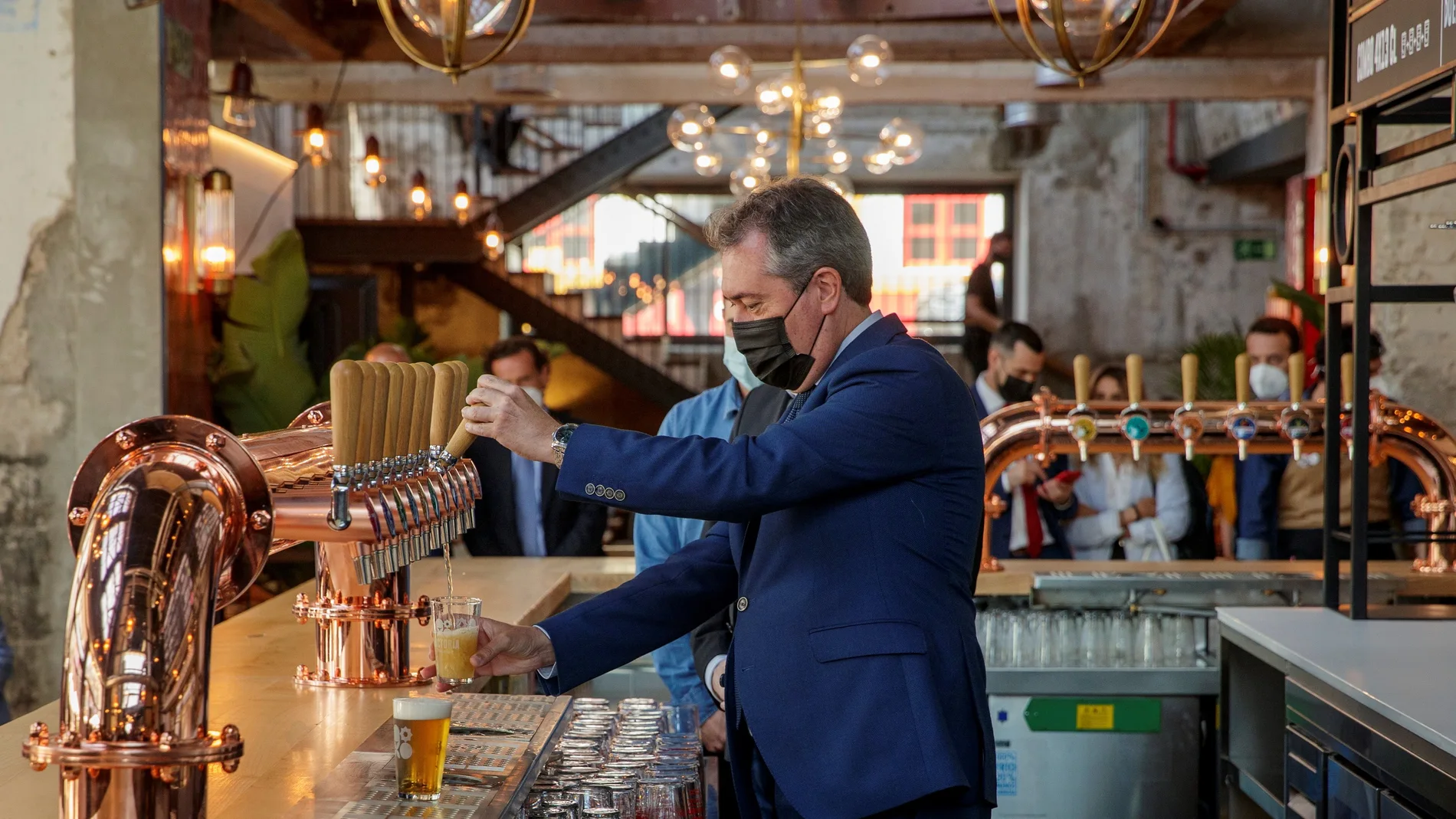 El candidato y alcalde de Sevilla, Juan Espadas, tira una caña de cerveza durante la inauguración hoy en Sevilla de la antigua fábrica de Cruzcampo
